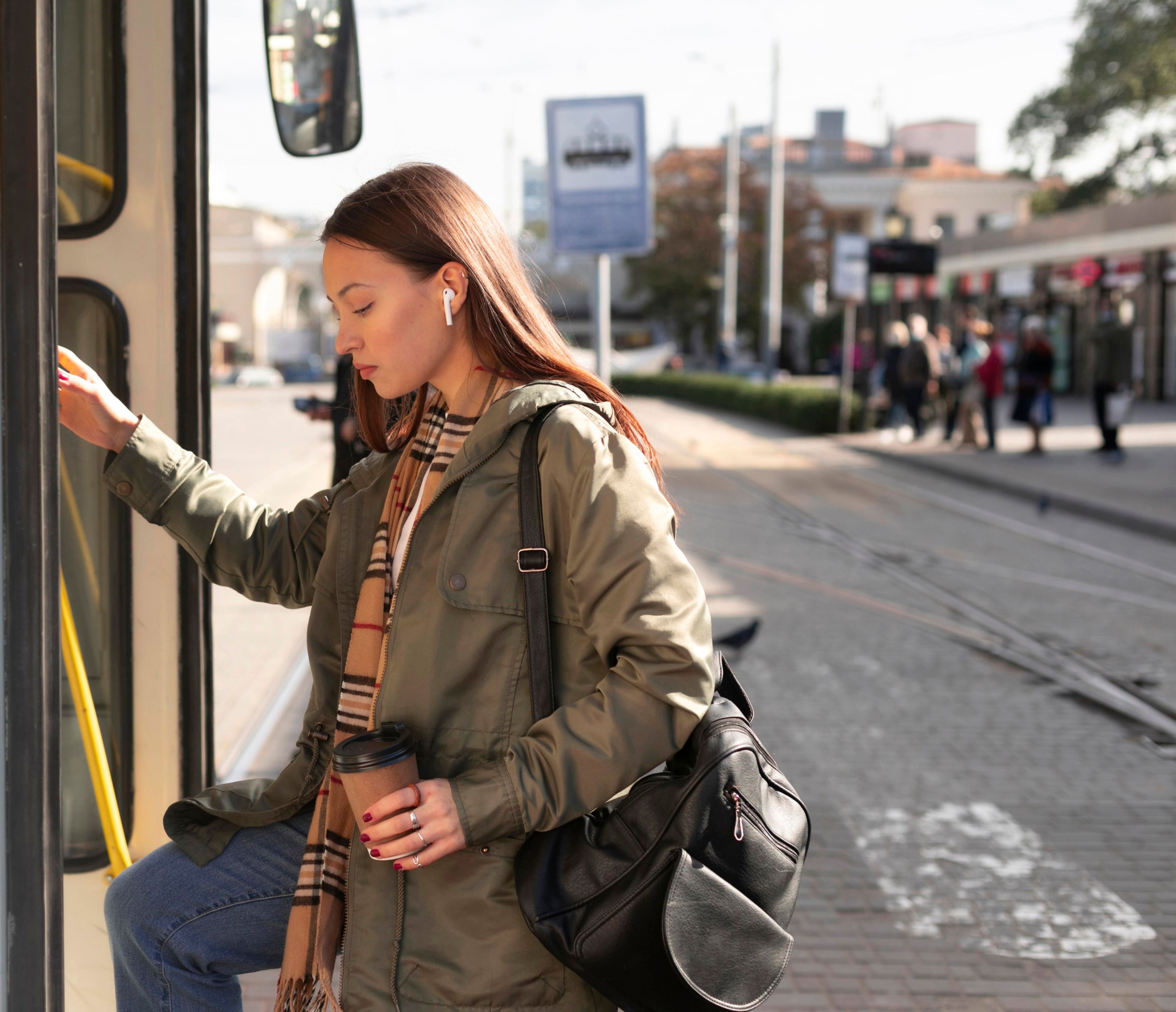 Persona che sale sul tram di profilo