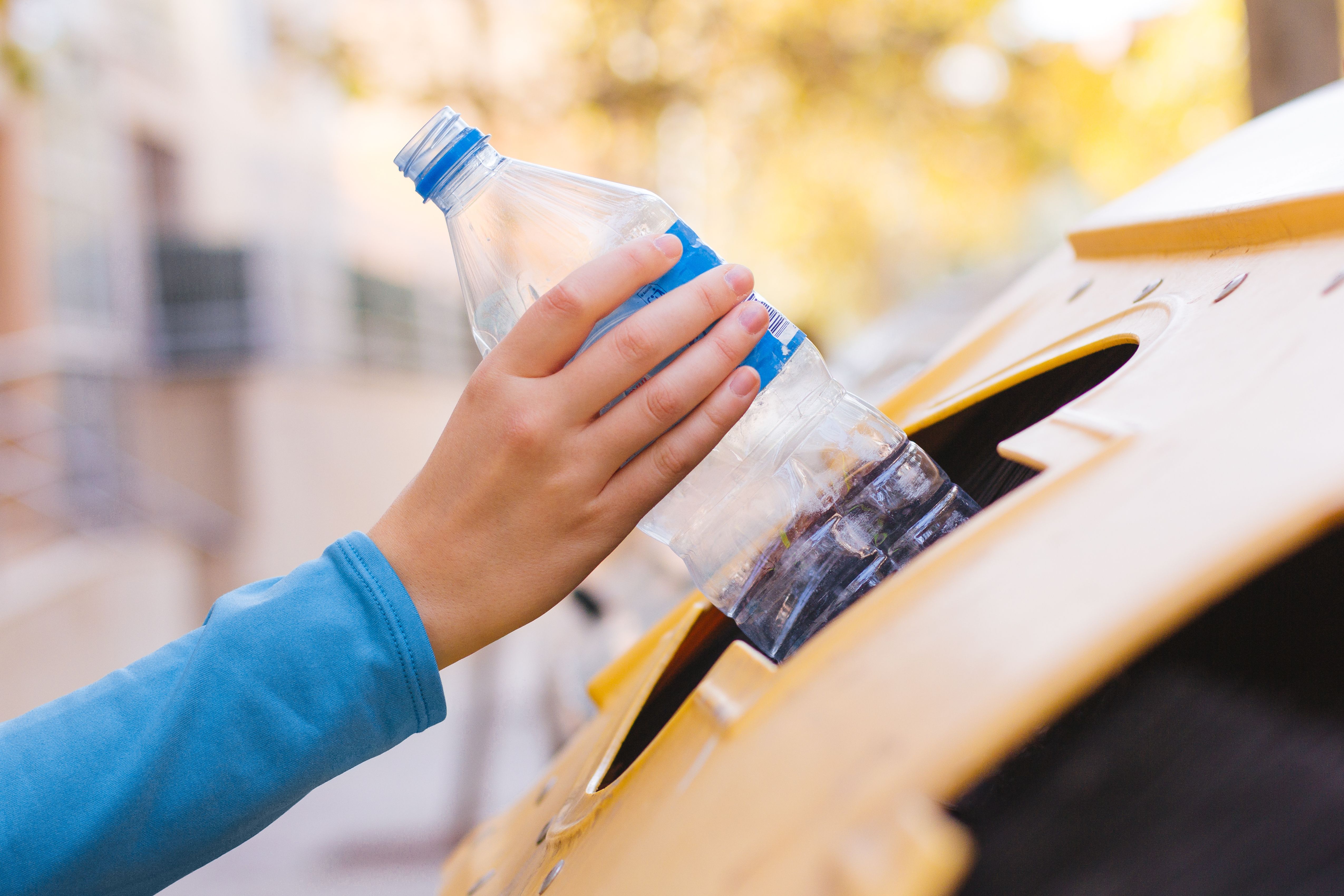 Donna che ricicla una bottiglia in plastica